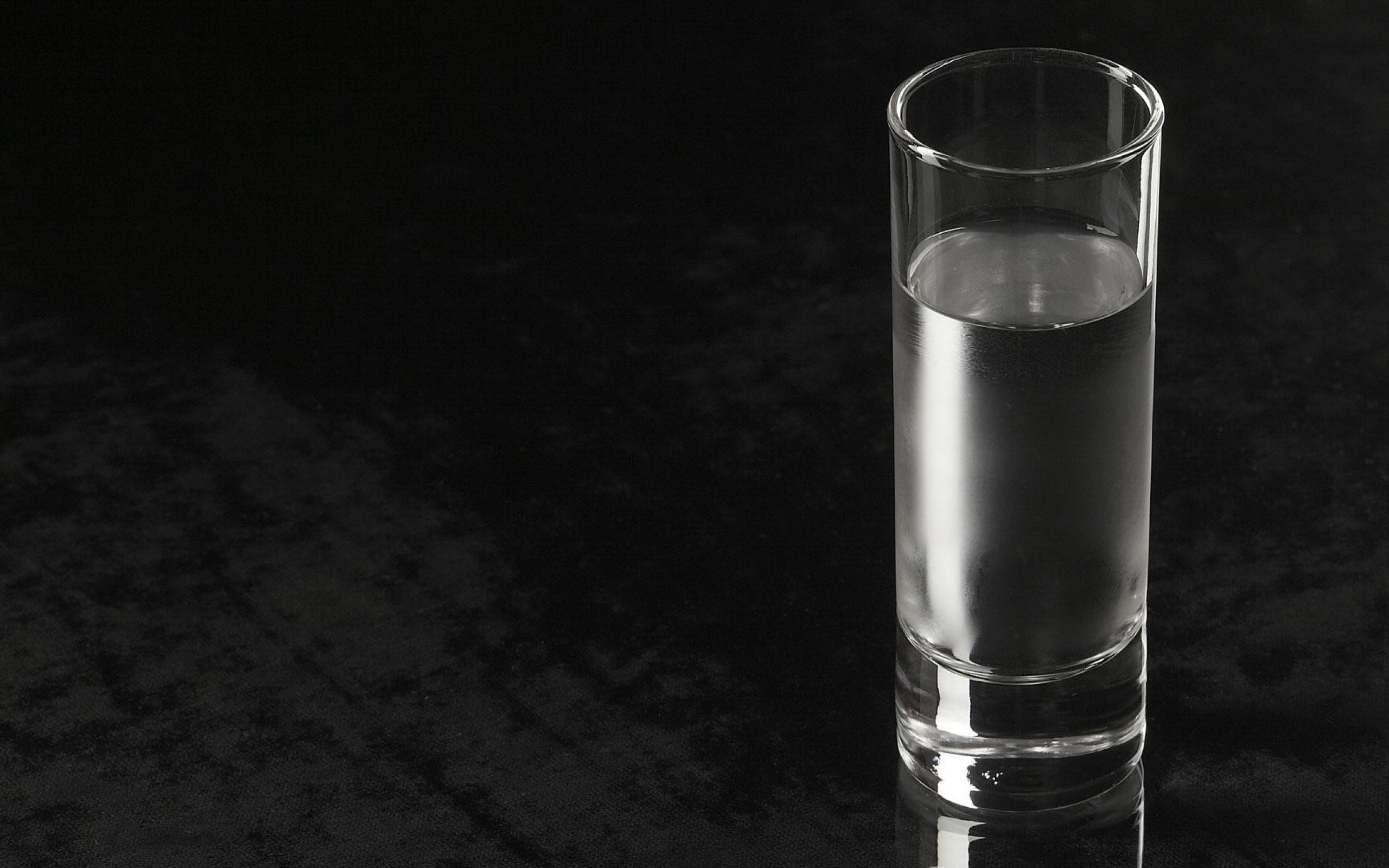 На столе пустой стакан. Стакан воды. Стакан воды на темном фоне. Стакан воды на черном фоне. Стакан воды Минимализм.
